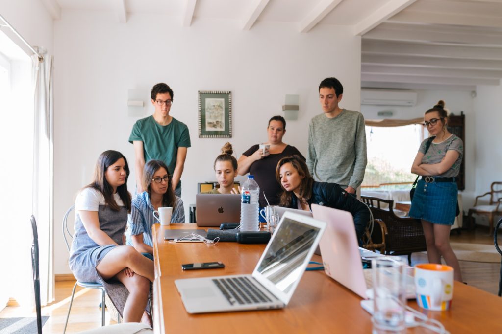 Empresa 4.0: Equipe de um escritório olhando para o computador de uma das integrantes. 