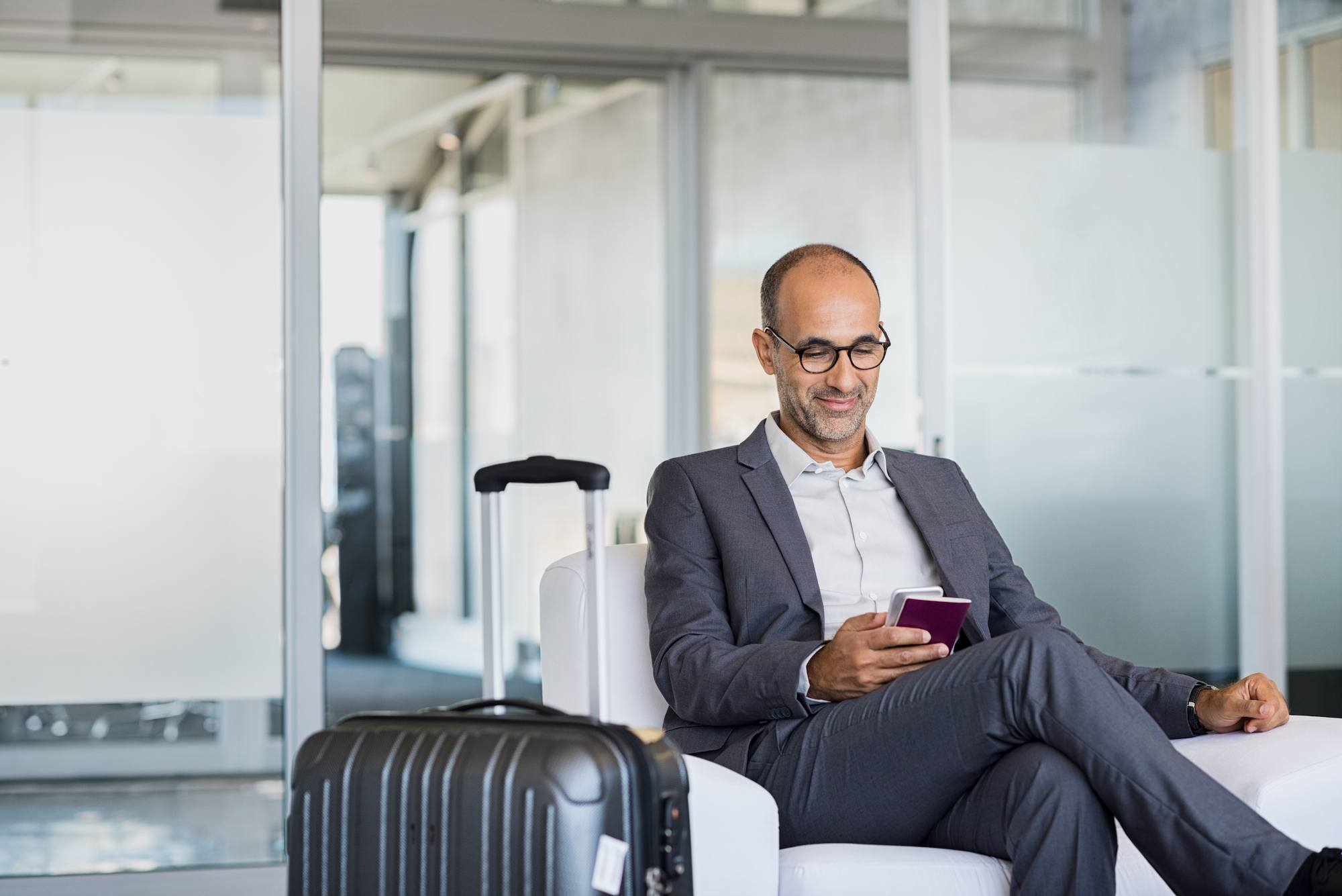 Homem de termo usa smartphone no aeroporto