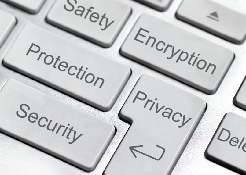 Imagem de teclas de um computador com  palavras privacidade, segurança, proteção e criptografia escritas. 