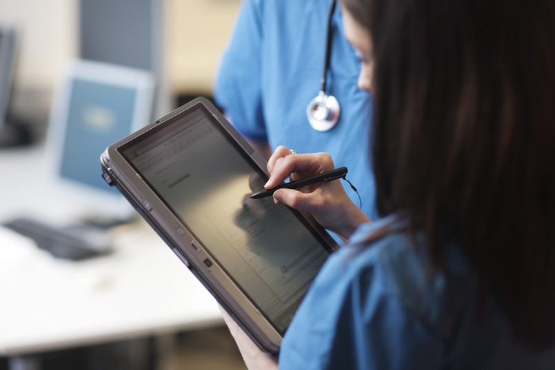 Imagem de uma enfermeira olhando um prontuário eletrônico. 