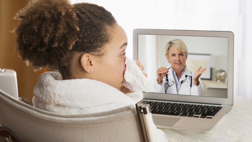 Transformação digital na saúde. Imagem de uma menina assoando o nariz em uma videoconferência com uma médica. 
