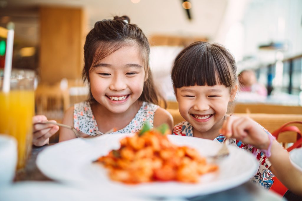 Crianças asiáticas comendo em restaurante