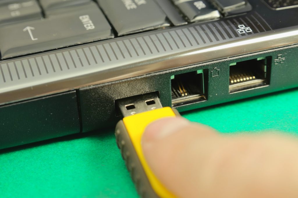 Imagem de pessoa colocando pendrive USB em laptop