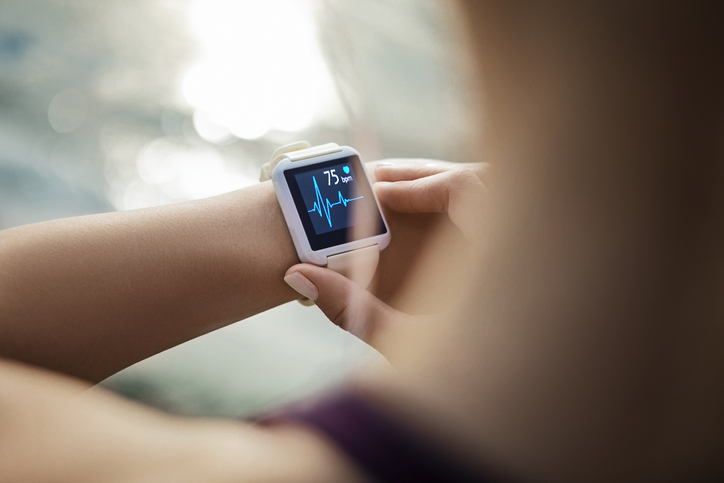 Foto aproximada de pessoa conferindo relógio inteligente no pulso