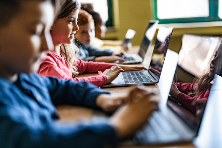 Crianças em mesa utilizando computador